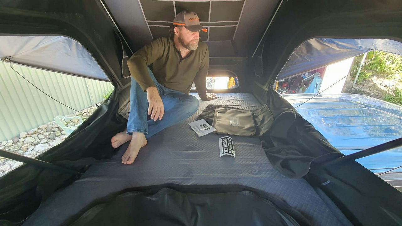 Kris sitting in the rooftop tent