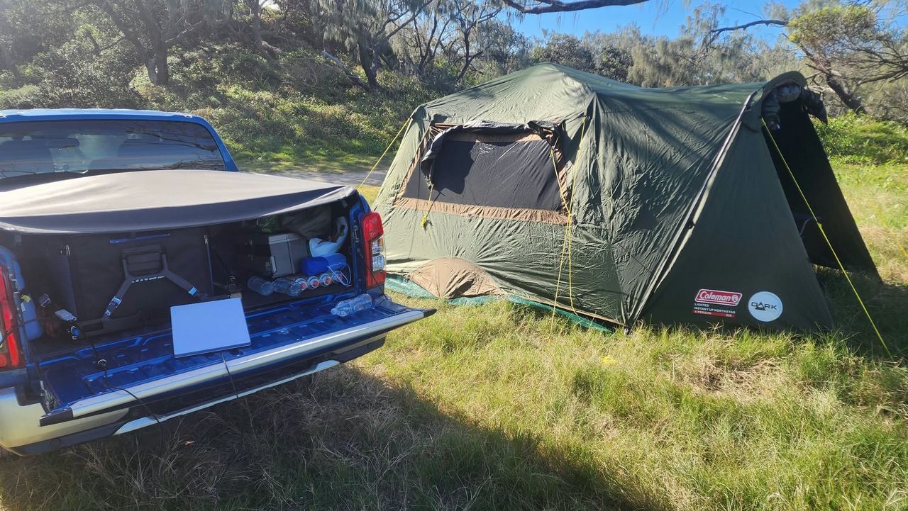 ground tent beside the ute at a beach camp