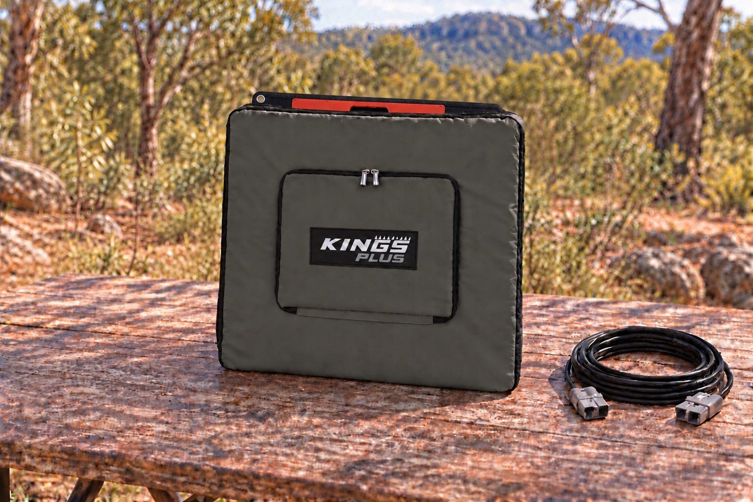 solar blanket folded inside its padded carry bag, the red carry handle showing at the top, beside the 6 m extension lead with its Anderson-style plugs